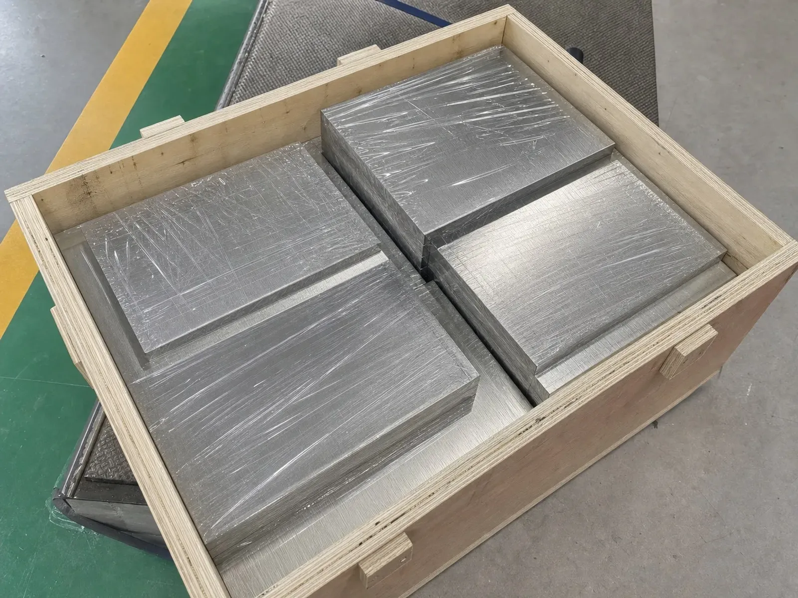 Metal plates stacked in an open wooden crate