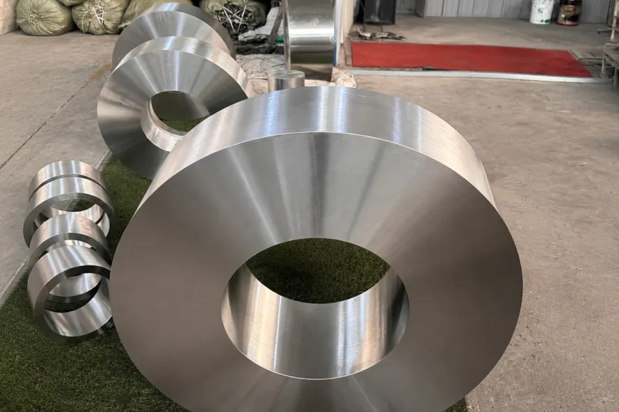 Large machined titanium ring blanks on a workshop floor, a visual reminder that accreditation still has to connect to a defined product form, route, and release record.