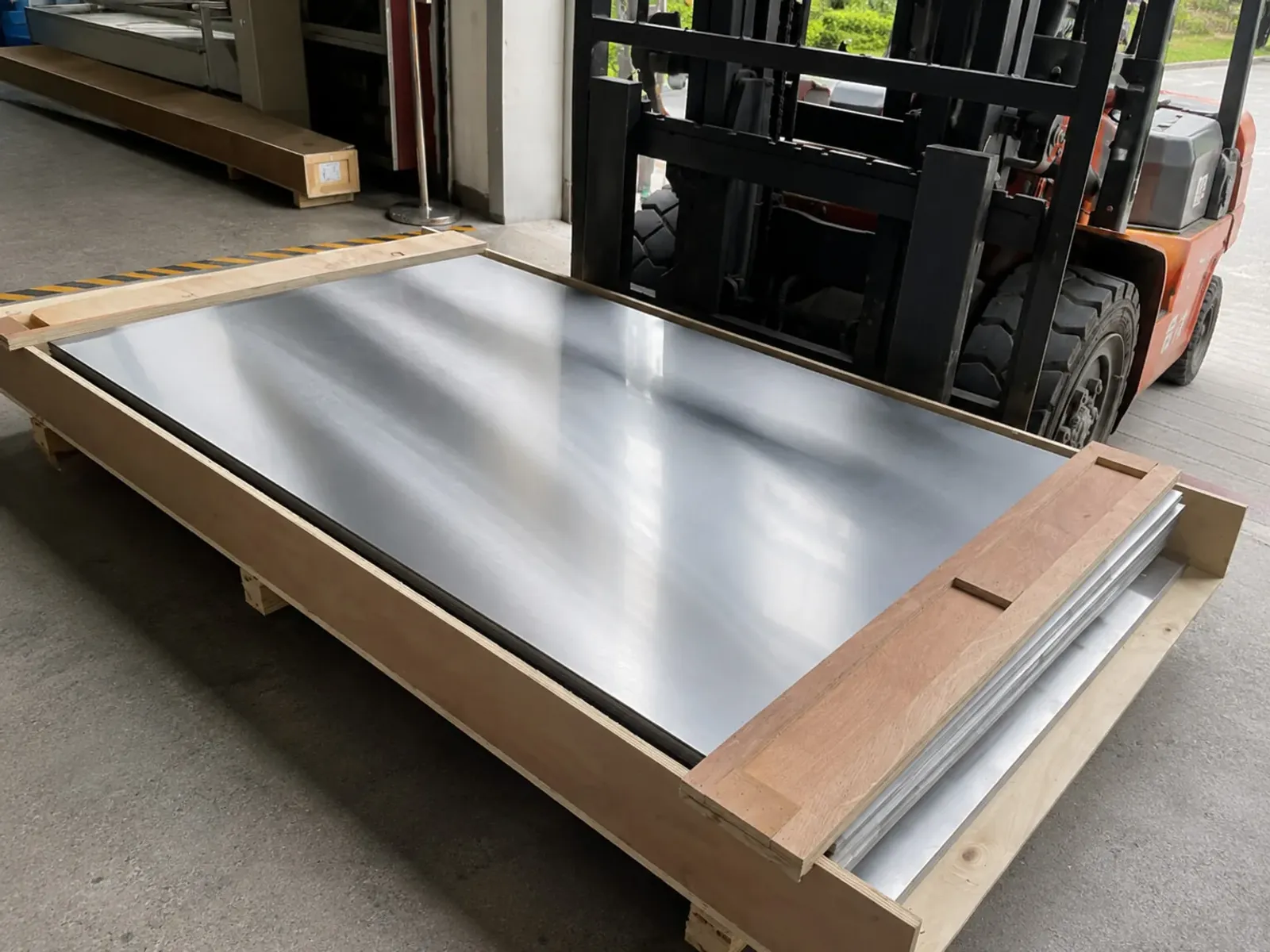 Representative titanium plate stock in protected handling shows the material input boundary for regulated manufacturing; it is not an implant.