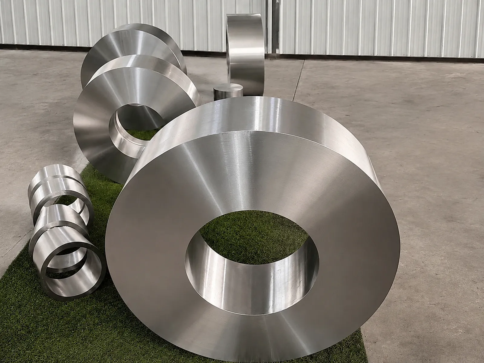 Clean titanium ring forgings in a workshop, showing product geometry that still needs route, heat-treatment and release evidence.