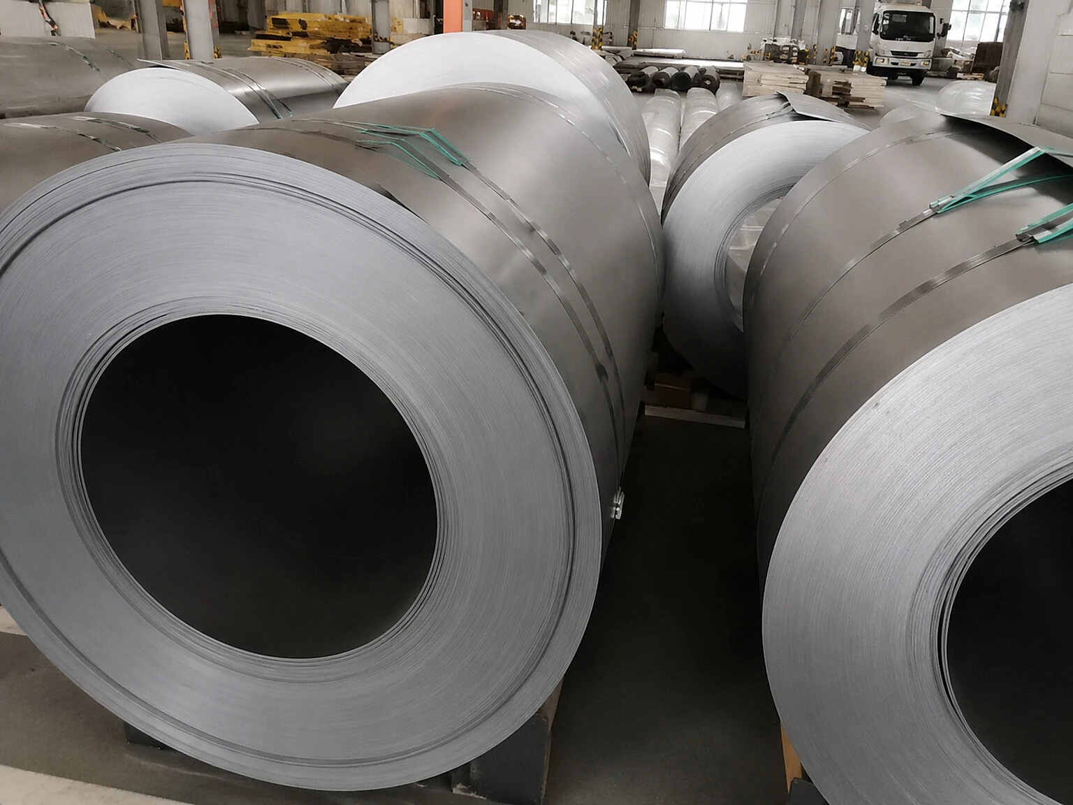 Coiled titanium-like sheet stock in a warehouse, illustrating that inventory value depends on thickness, condition, specification, and conversion readiness.