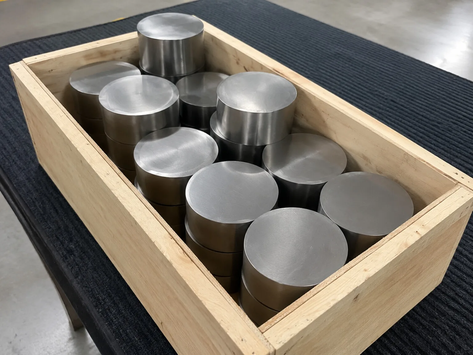 Titanium billet discs grouped in a crate show the upstream lot identity that must stay connected to a representative device family