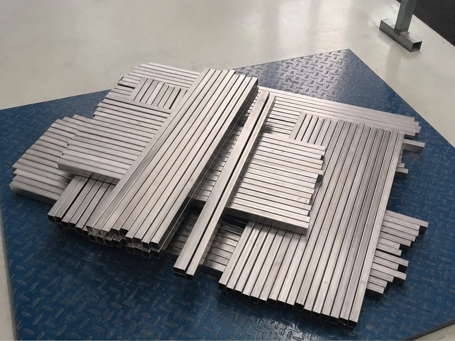 Representative precision-cut titanium strips show the small sections and edge population that require lot-level control in thin, patterned assemblies.
