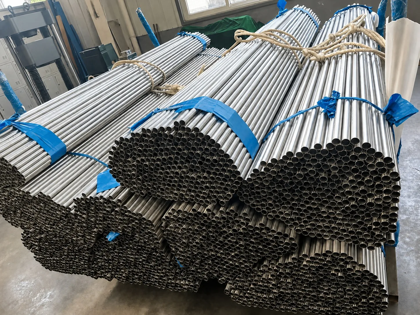 User-supplied titanium tube bundles show the product form whose surface and dimensional consistency can depend on hot-extrusion interface control; they are not study specimens.