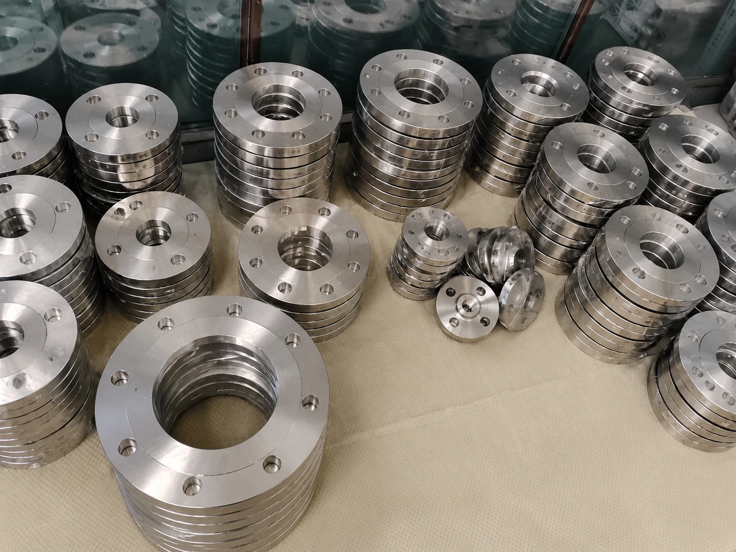 Machined titanium flange batches arranged by size, showing why part-level release has to preserve drawing, lot, and inspection identity across repeated geometry.