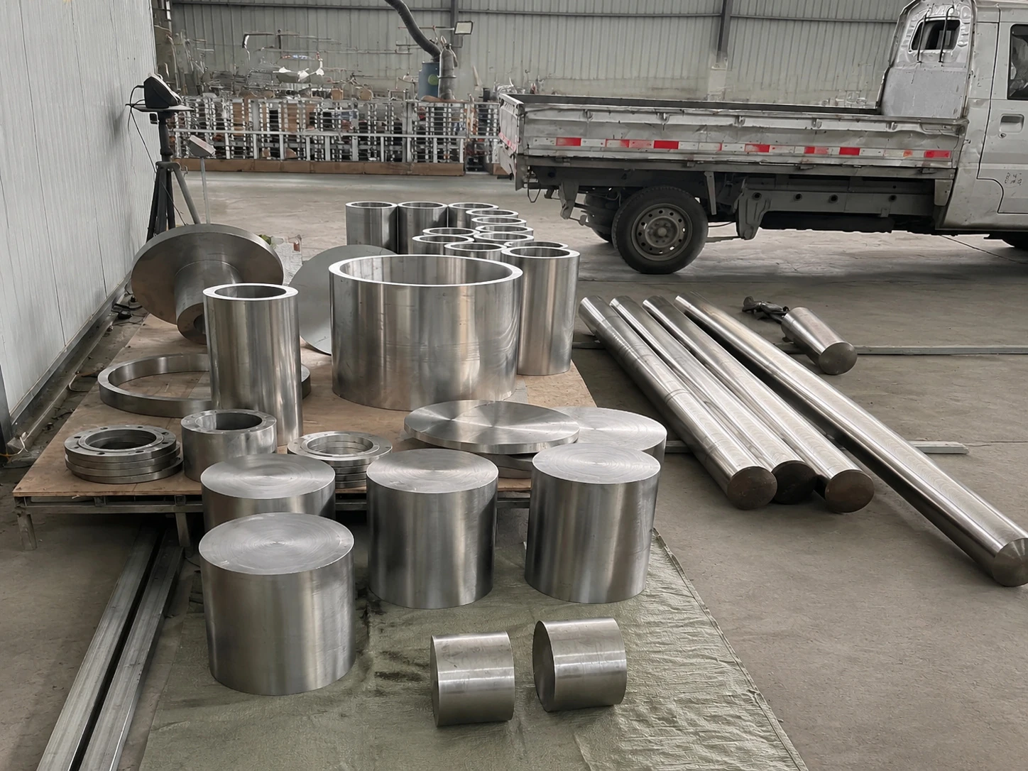 Titanium bars, rings, tubes, and machined blanks staged together in a workshop, illustrating why buyers need product-form boundaries before applying a process credential.