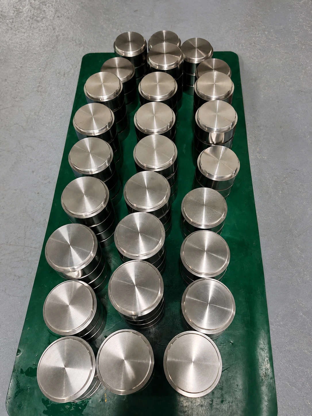 A batch of machined titanium discs shows why repeated part geometry, surface finish and lot identity must be controlled before a coating claim can travel with the component.