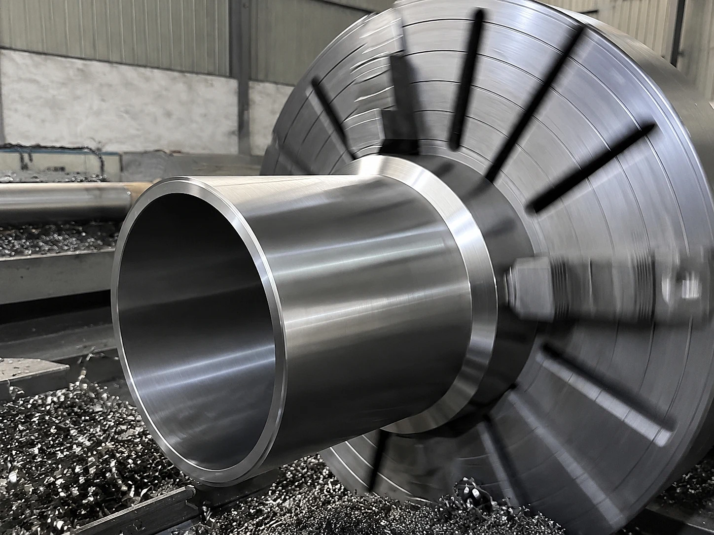 A titanium-like tube being machined on a CNC lathe, illustrating that route control remains part of the release file after alloy mixing.