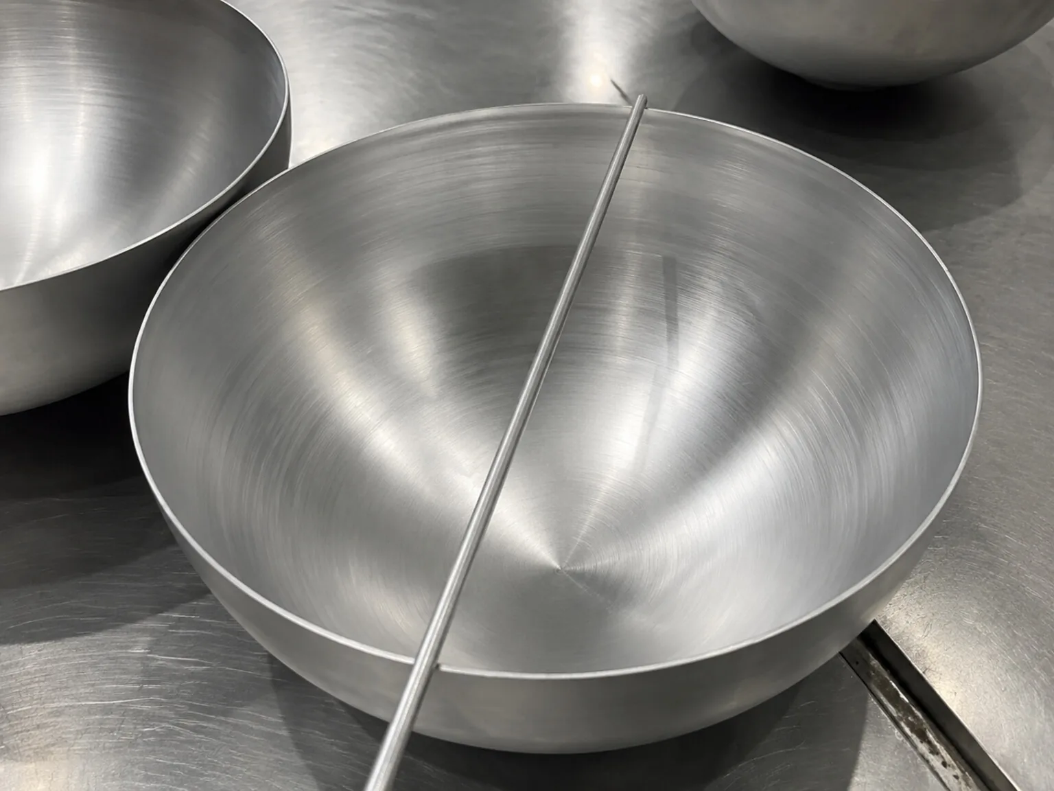 Representative formed titanium components illustrate how material stock becomes application-specific geometry; the image does not depict the announced cradle.