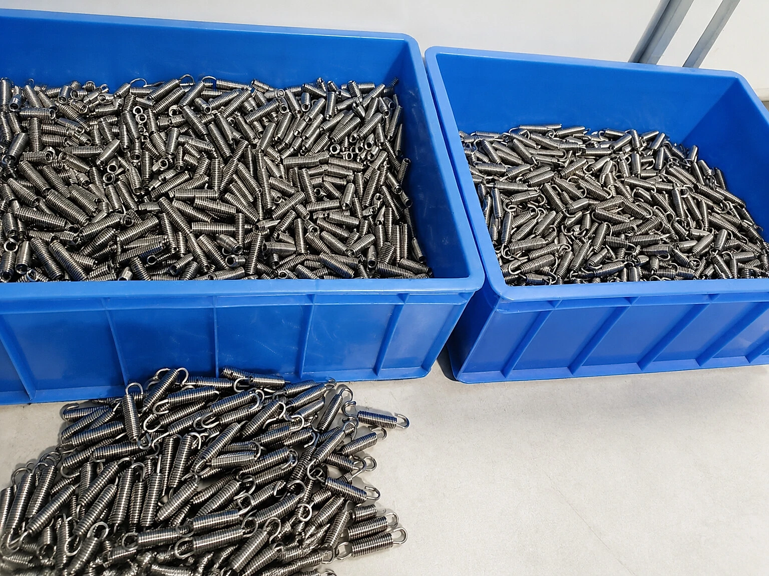 Small titanium components in segregated bins show why configuration identity must follow parts whose material state carries both service and end-of-life functions