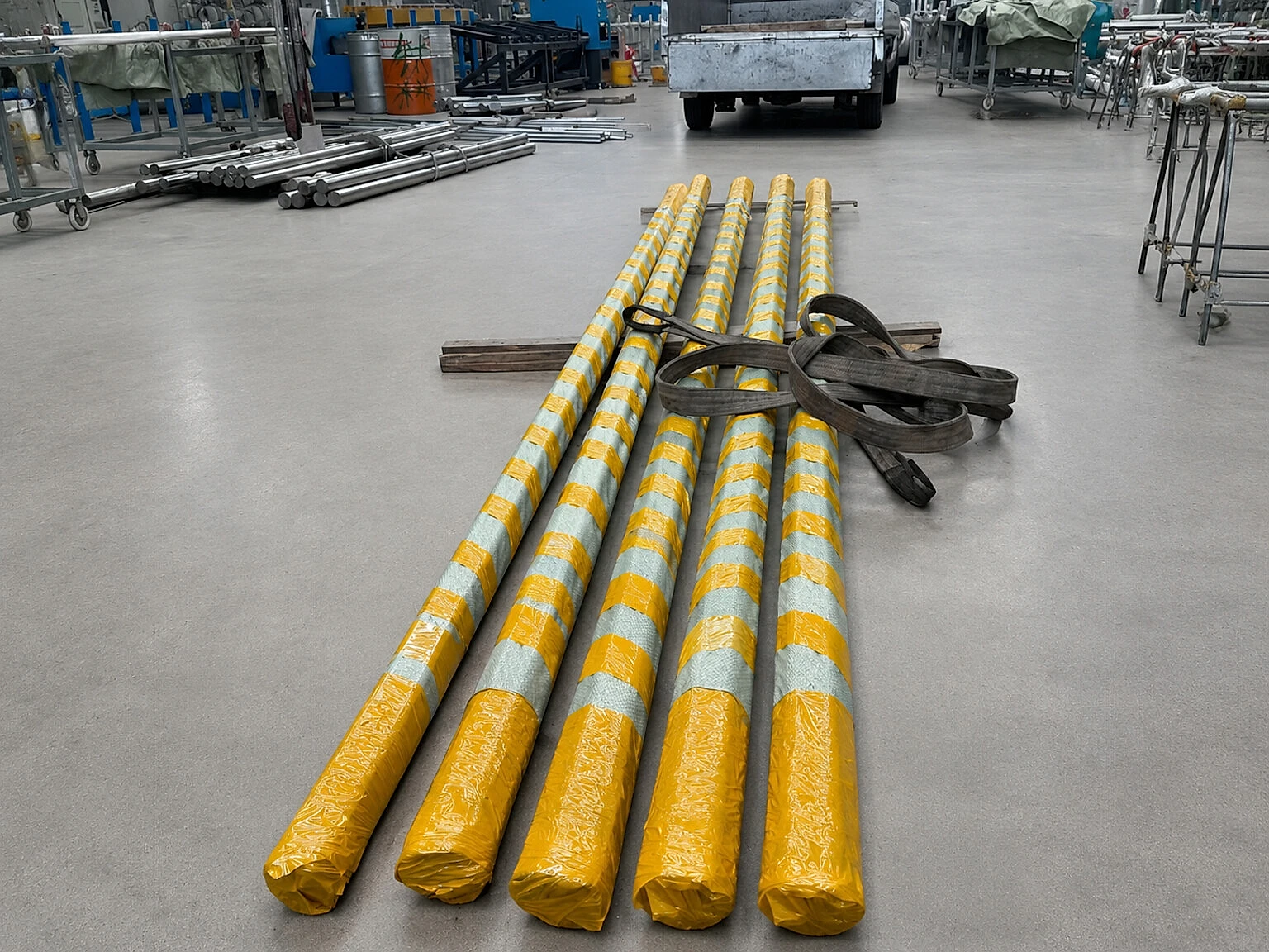 Protected titanium bar bundles on a factory floor show the handling and allocation work that sits between nominal stock and order-ready supply