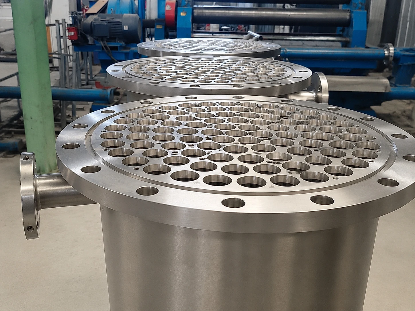 Titanium tube-sheet components in a workshop, illustrating that strategic material availability must still pass through product-specific conversion, inspection, and release steps.
