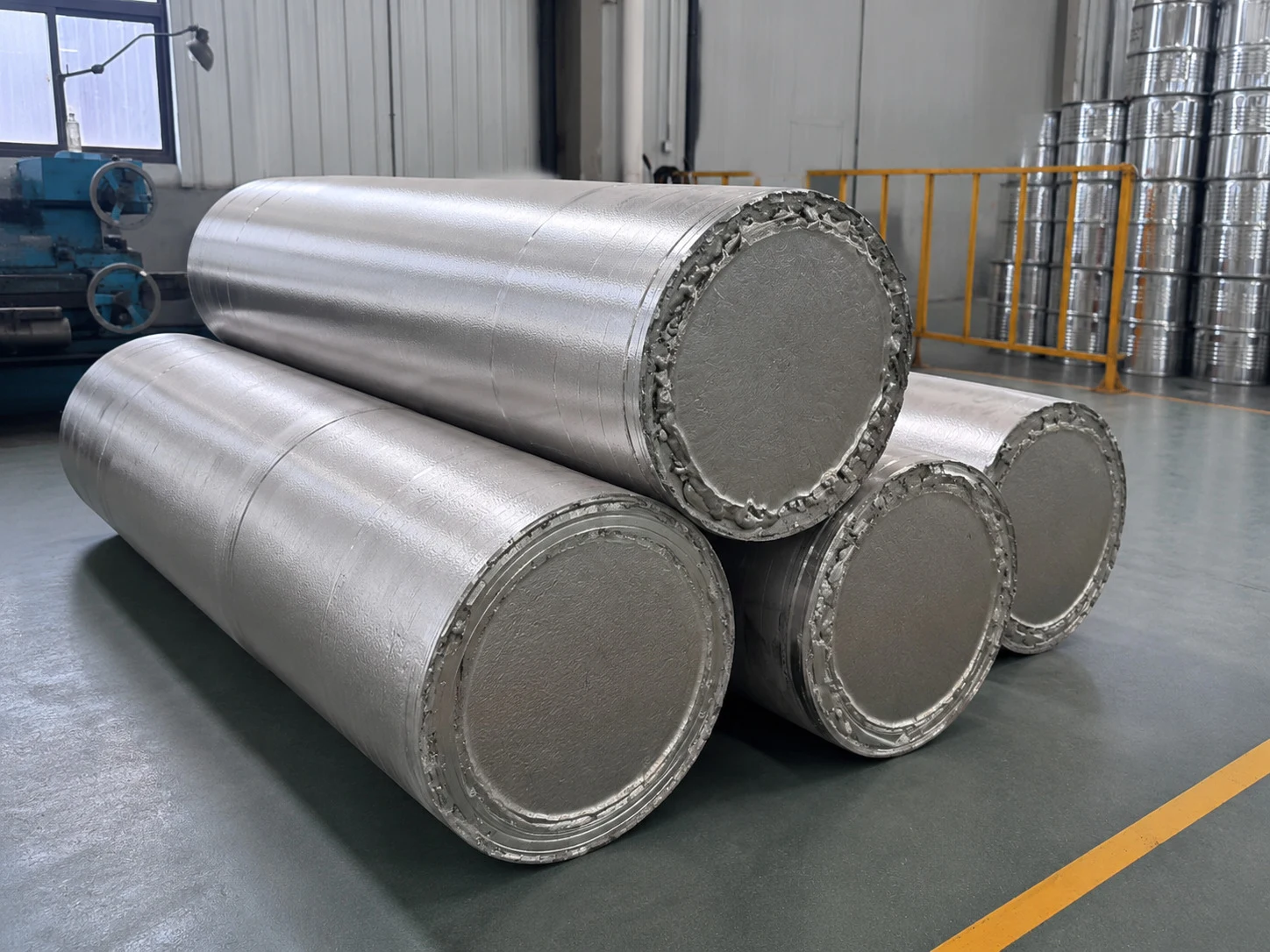 Large titanium-like round billets staged in a workshop, showing the kind of product-form baseline buyers still need when comparing deposited routes with conventional stock.