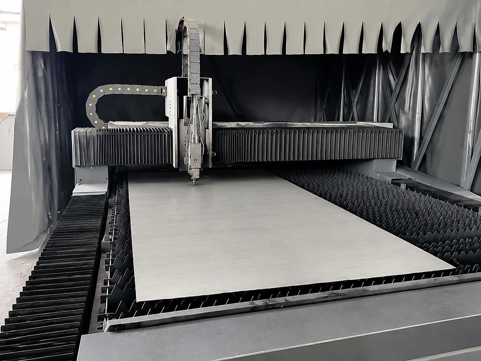 A metal cutting table with a plate in process, representing the post-build cutting and geometry-control steps that often follow large-format metal manufacturing.